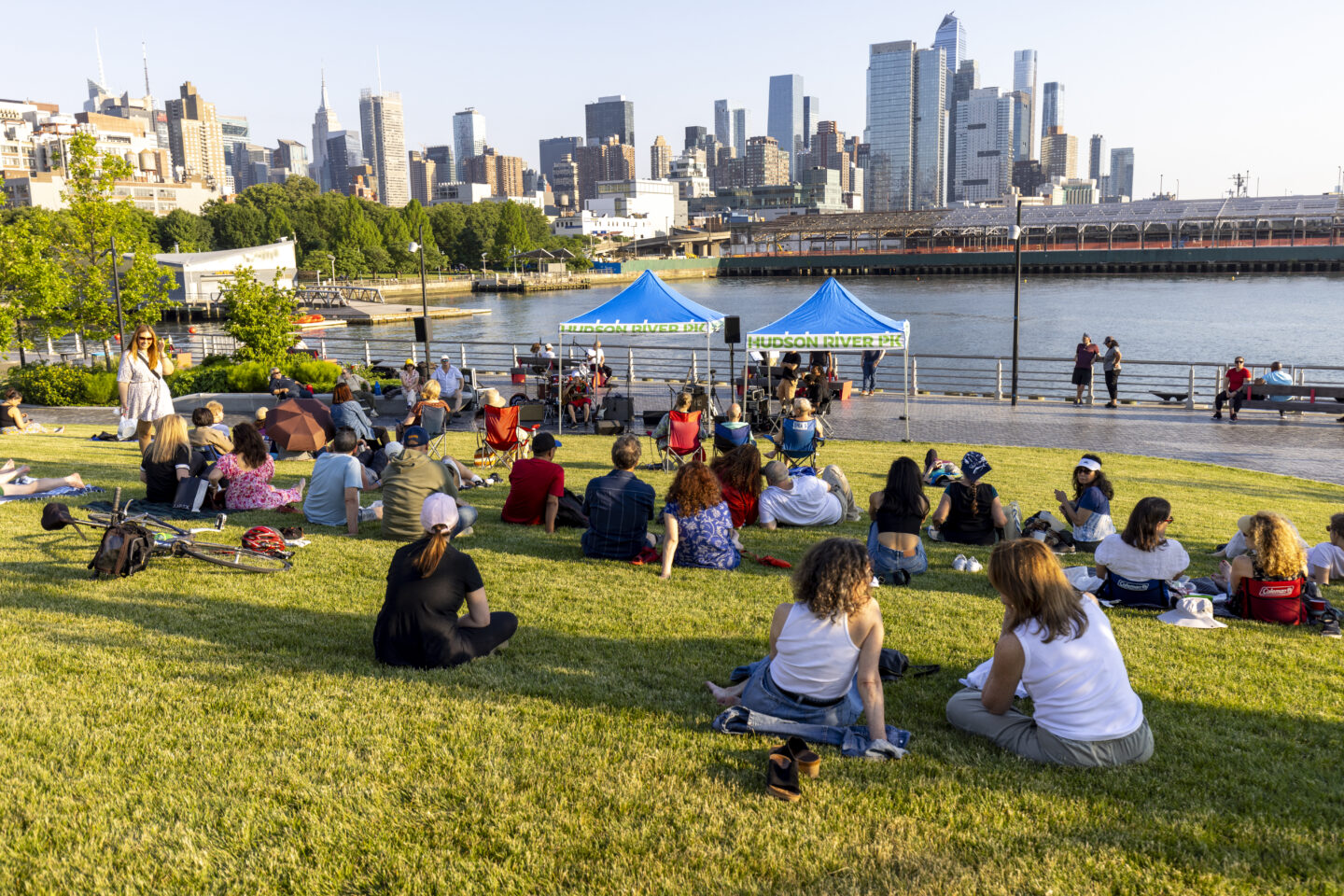 People listen to live music on the lawn at Pier 97 during a Blues by the Boardwalk concert