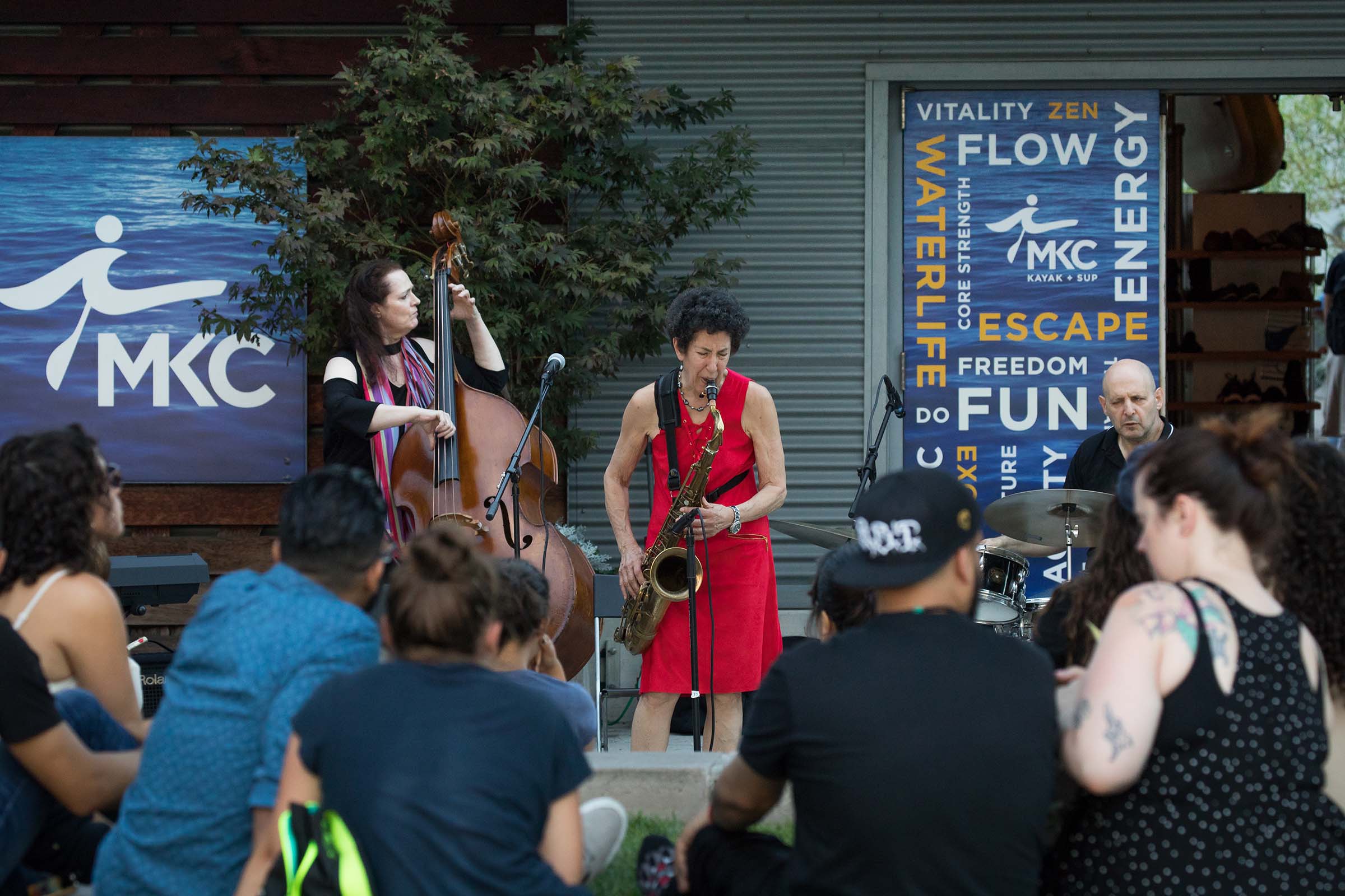 A lady in a red dress swinging with her tenor sax