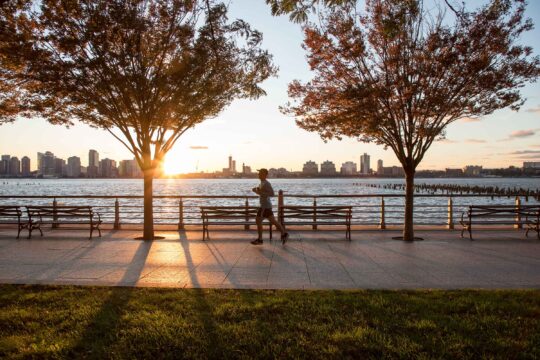 A jogger heads down the esplanade during sunset in Hudson River Park