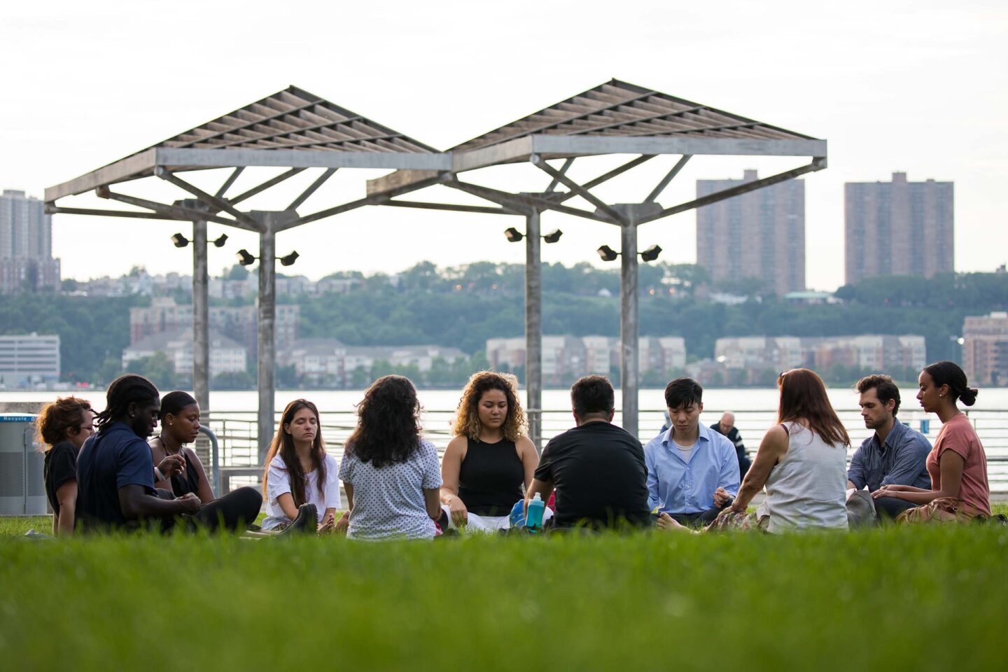 A group gathers in a circle and mediates at Pier 95
