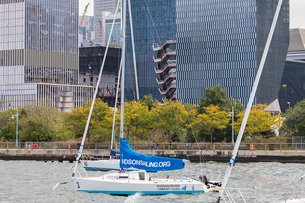 Sailboats from Hudson Community Sailing sit in front of green and gold trees