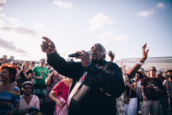 Another performer holds his mic and passionately sings the blues