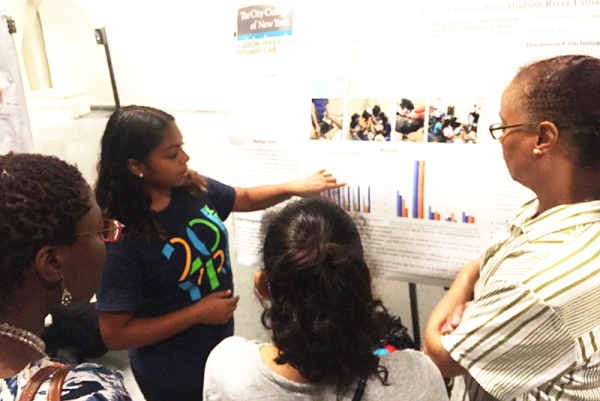 An educator points to a chart and explains some of the scientific evidence to a group
