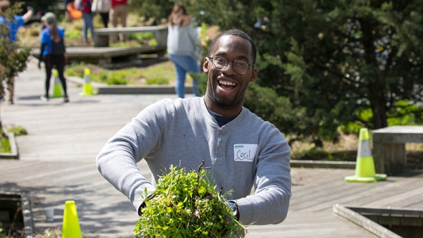 A volunteer grabs a bunch of dirt that will be placed in the flower beds