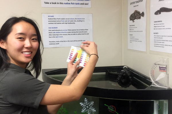 A Park educator checks the waters PH balance in the aquarium