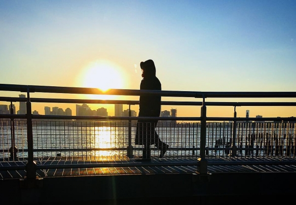 A sunset photo of a person strolling in the park by @antononwatch