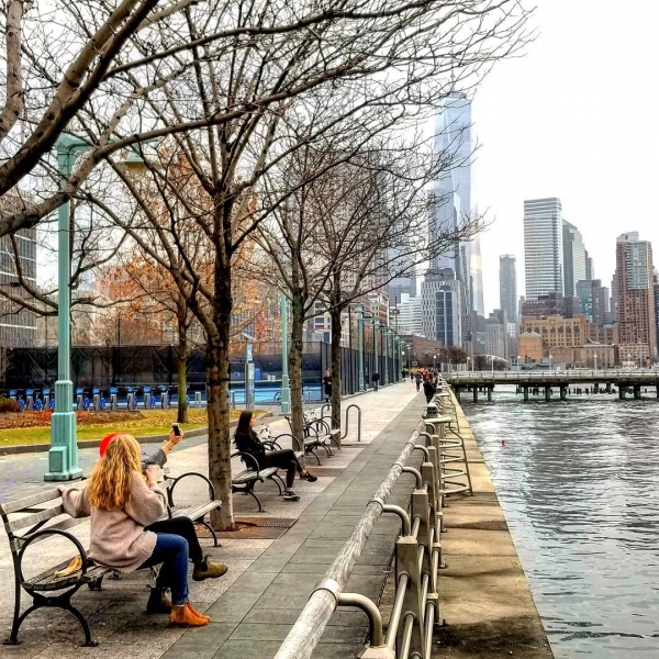 Park visitors take a seat on a beach along the esplanade near Pier 40