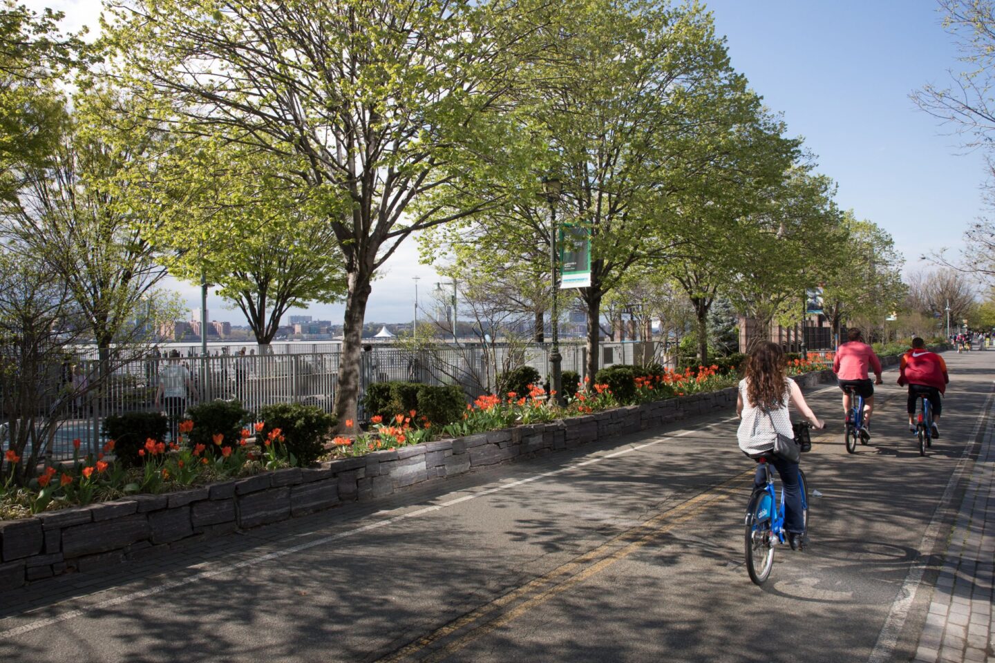 People biking on the Hudson River Greenway bike path outside the Leroy Street Dog Park