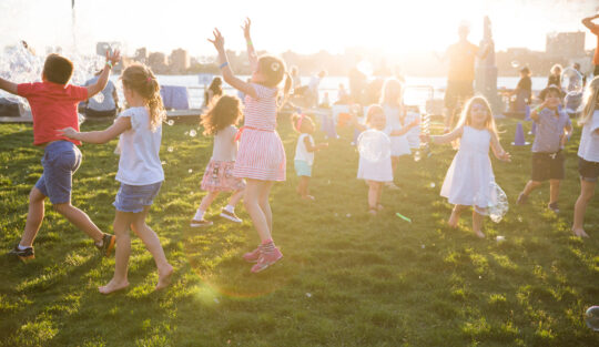 The sun glimmers around the kids at the bbq