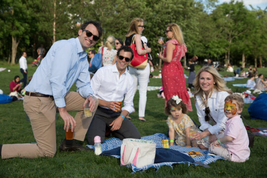 Parents smile at the camera at the bbq