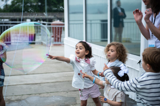 Kids touch the large bubbles at the bbq