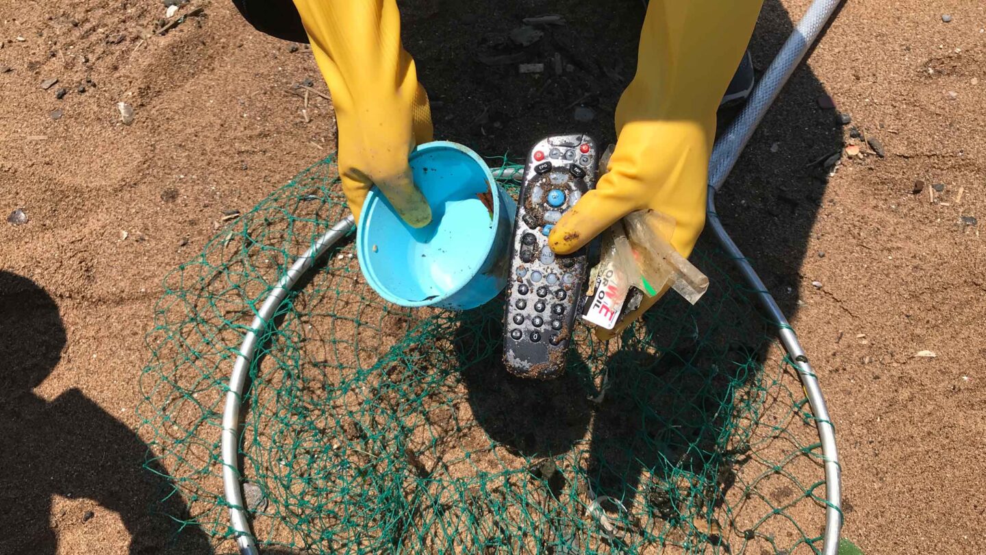 A plastic remote and cup found in the water