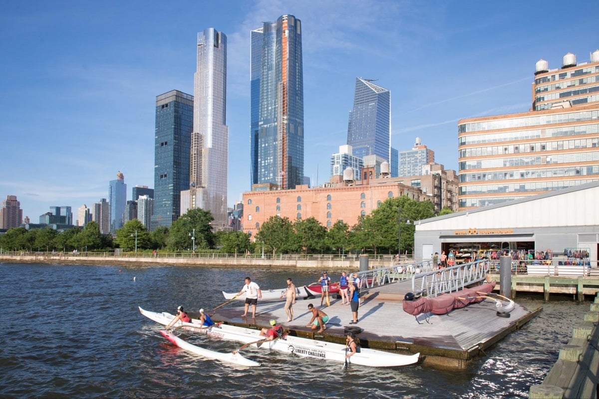 Kayaks launching from Pier 66 with Midtown buildings visible in the distance