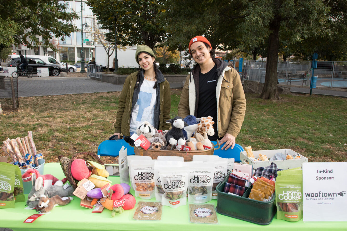 Hudson River Park Friends pose in front of dog treats from our sponsors at HRPK's Barktoberfest
