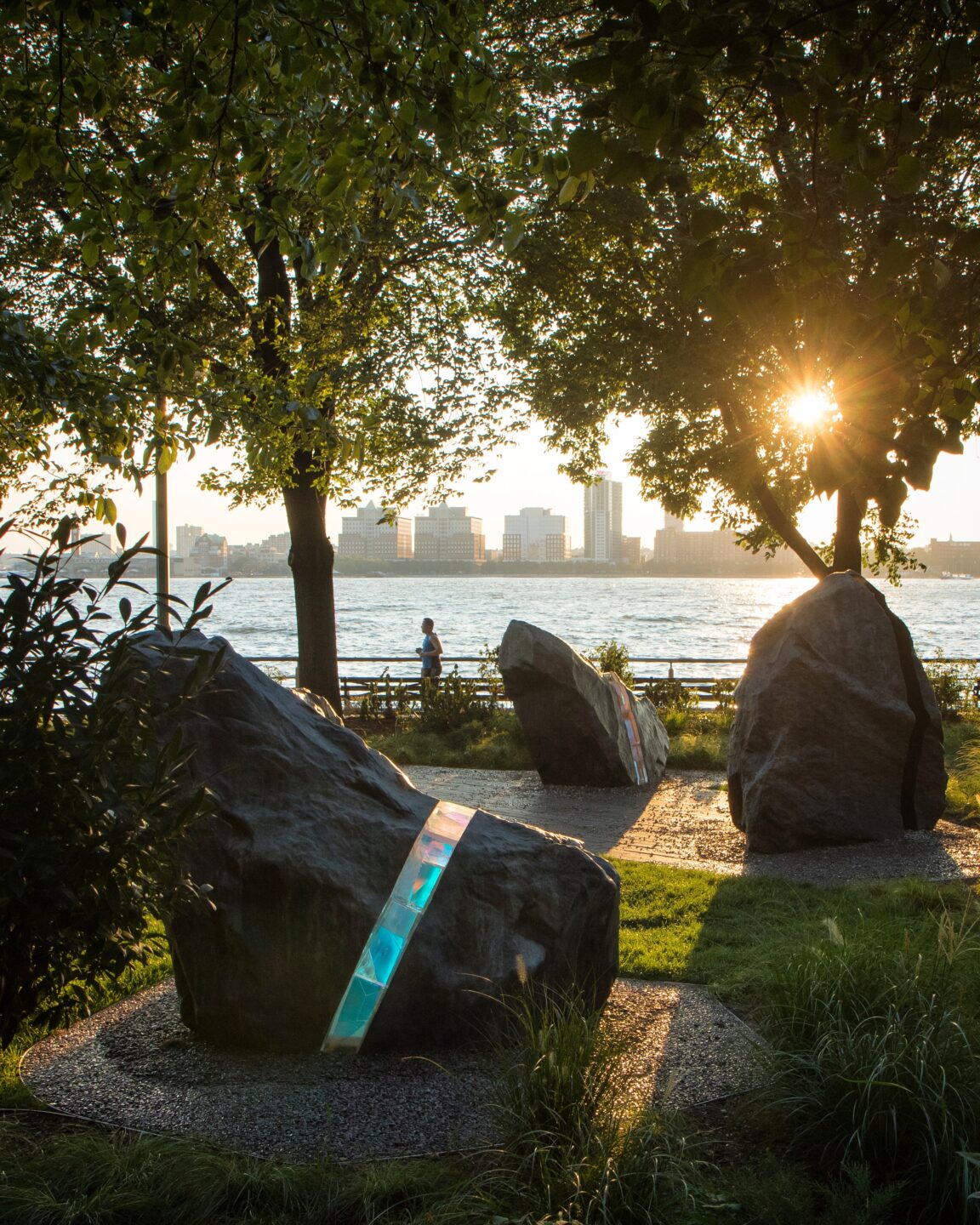 The LGBT Memorial in Hudson River Park, featuring boulders bisected with a clear, laminated, borosilicate-glass with refractory components that act as a prism to create subtle rainbow patterns on the surrounding lawn and nearby objects