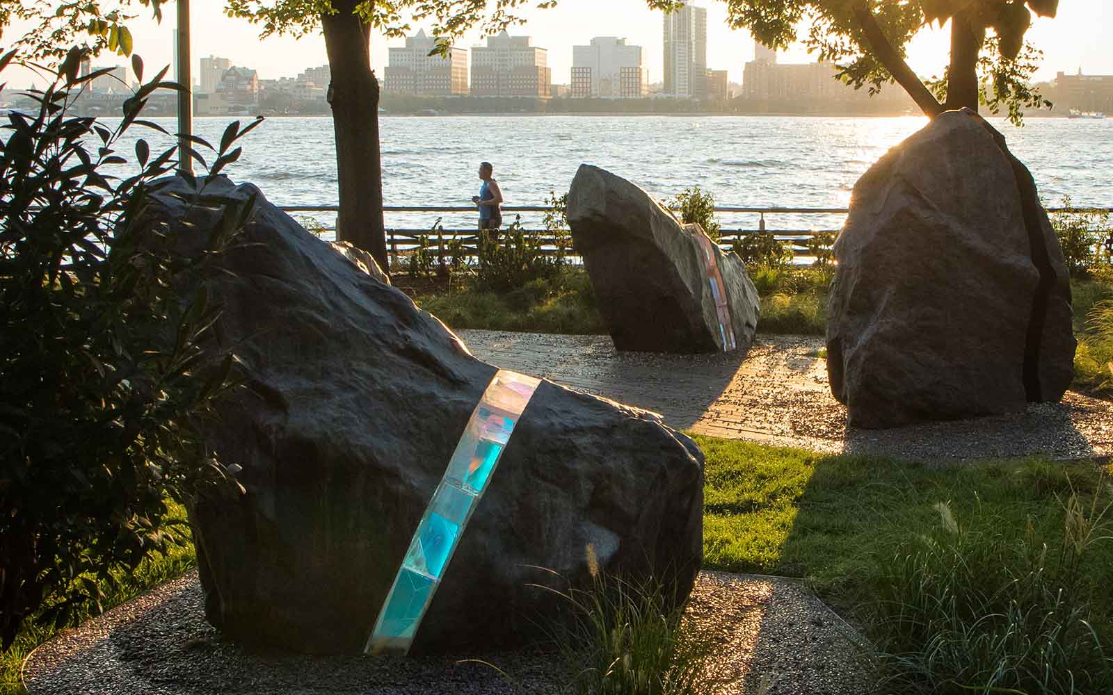 The LGBT Memorial in Hudson River Park, showing bronze boulders, some of which are bisected by laminated glass with refractory components
