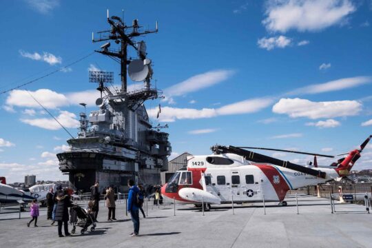A red and white helicopter sits on the roof of the Intrepid on Pier 86 at Hudson River Park