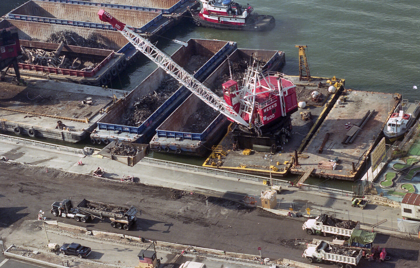 A construction crane moving debris from the World Trade Center into barges near Pier 25.