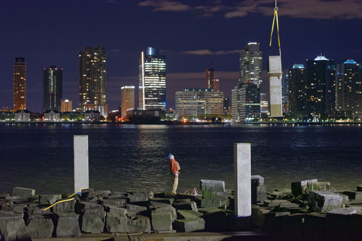 A construction worker looking up at a steel column during the construction of Pier 26.