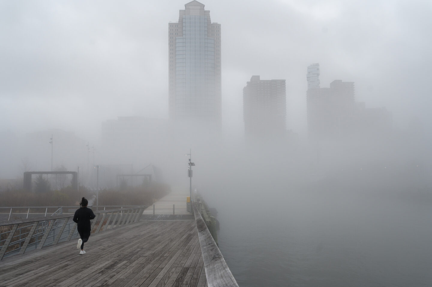 A runner on Pier 26 during a foggy morning.