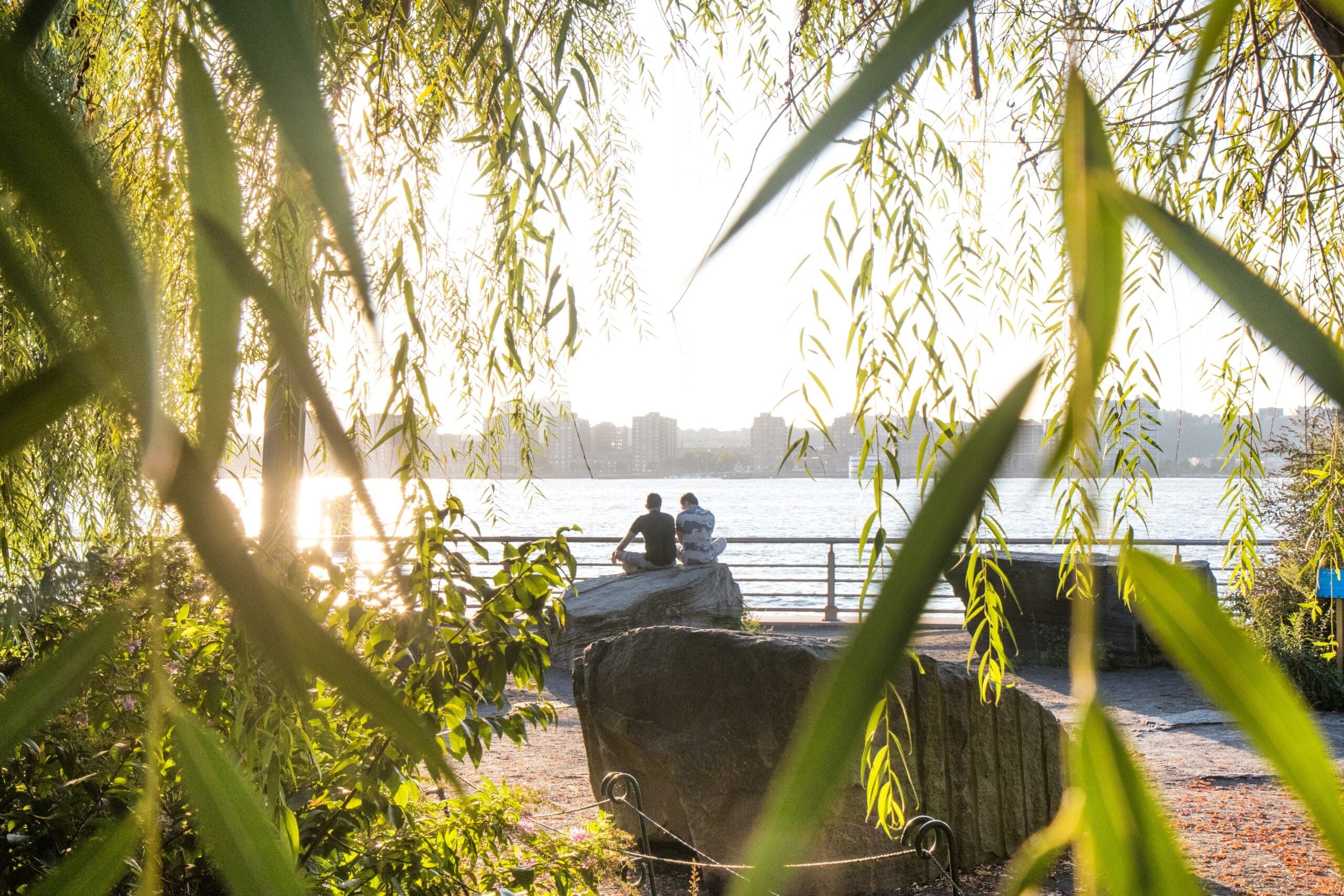 Two people sitting on a stone in the Stonefield at Pier 63.