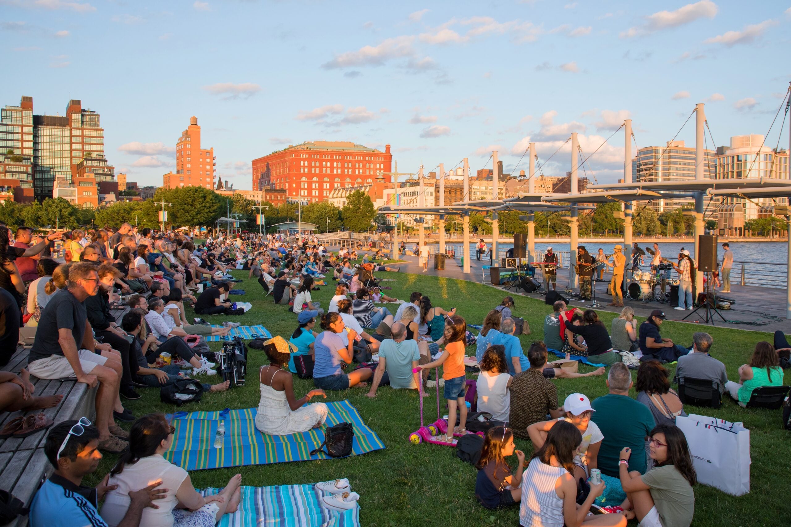 A crowd sitting on the grass at a Sunset on the Hudson concert at Pier 45.