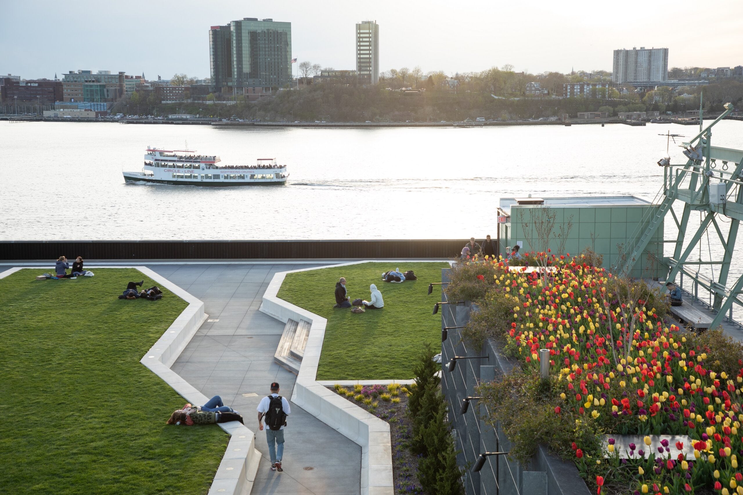 The Pier 57 Rooftop park with a Circle Line cruise passing by on the River.