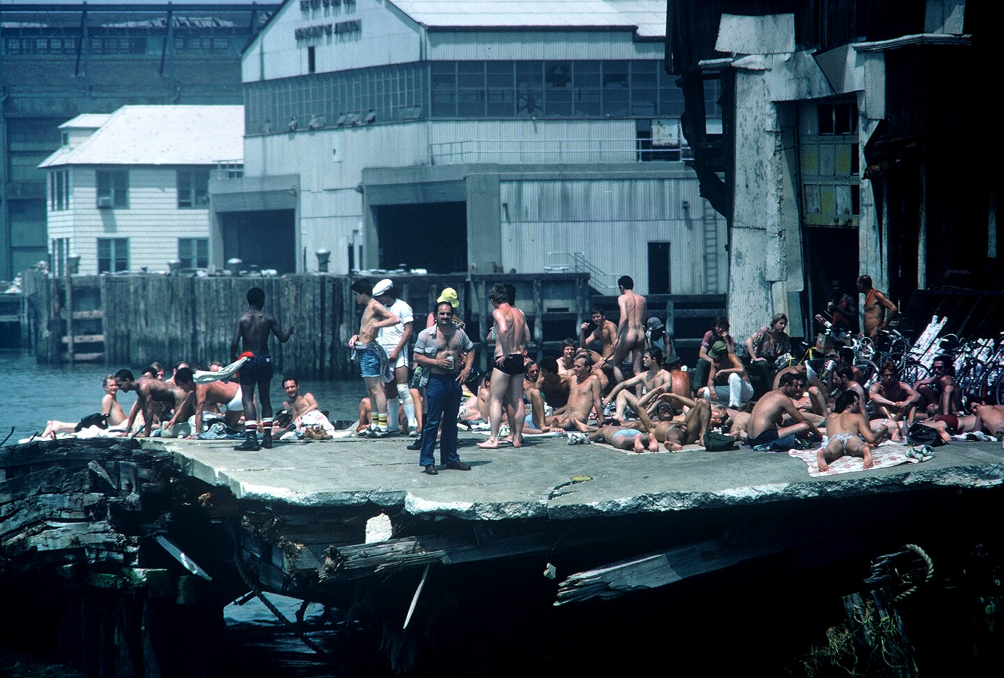 Men sunbathing on a crumbling Hudson River pier.