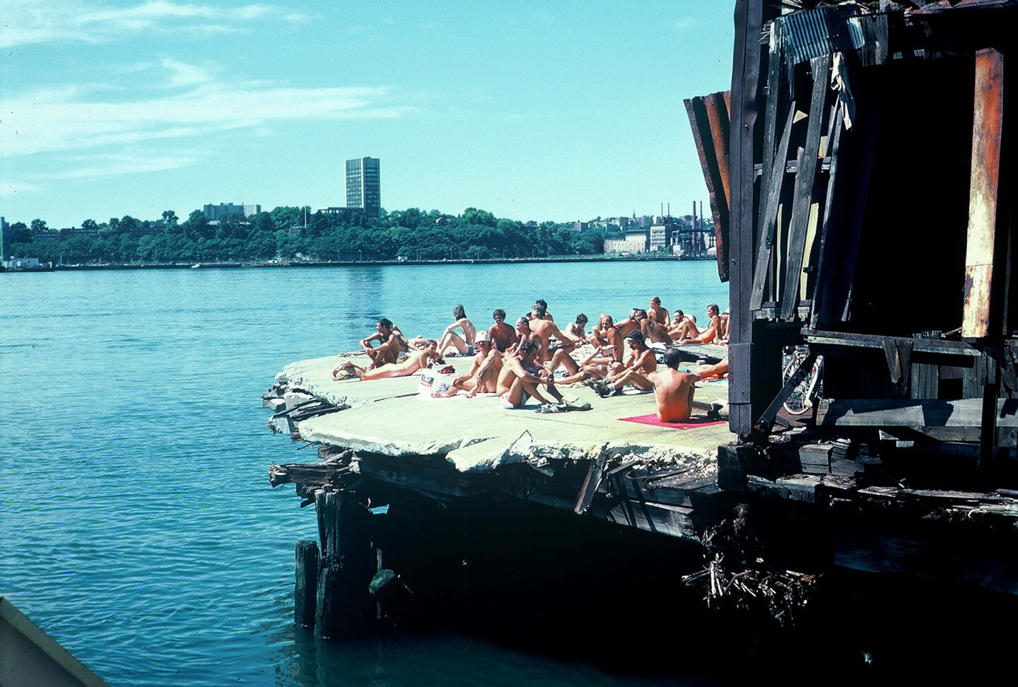 Men sunbathing on a crumbling Hudson River pier.