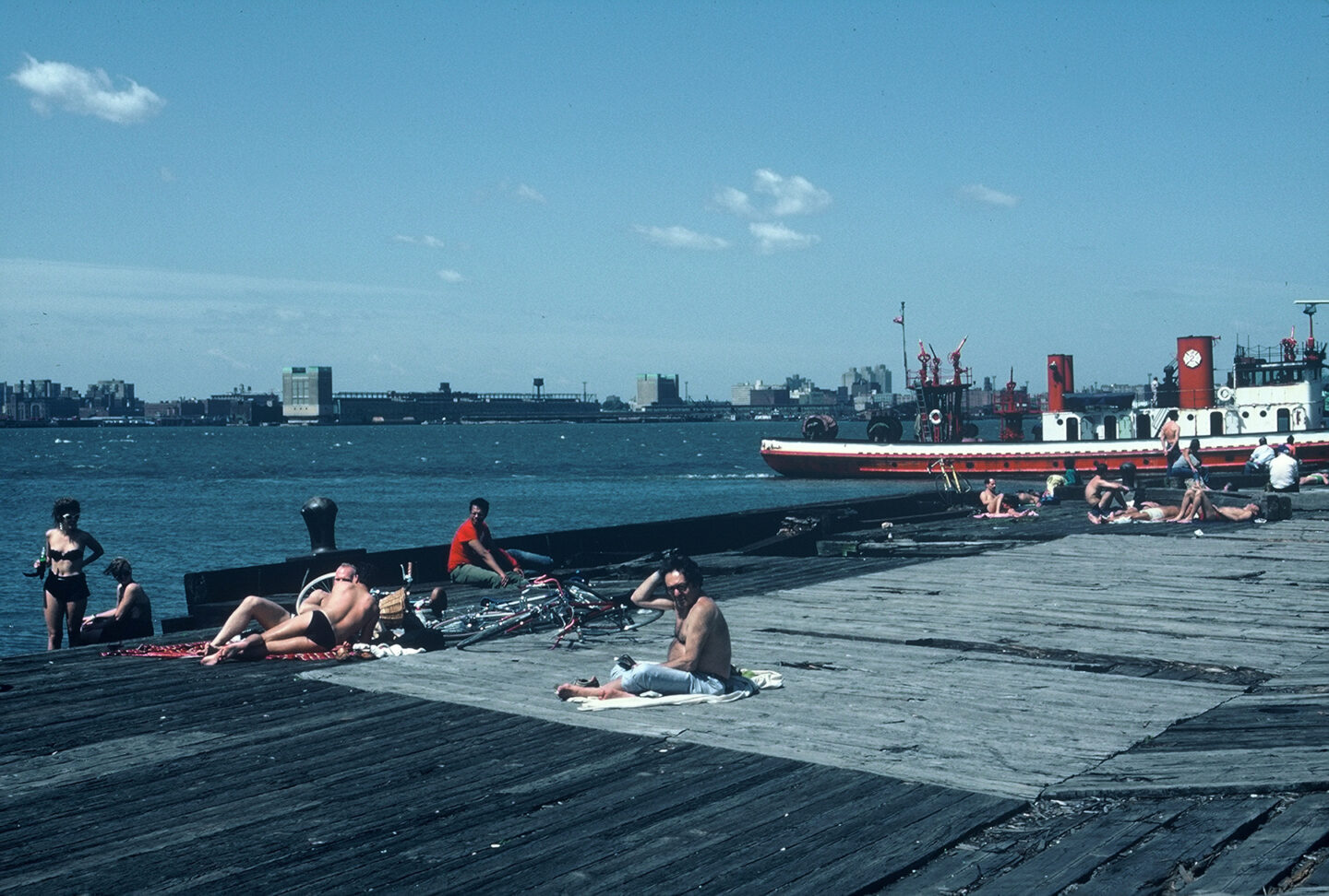 People sunbathing on a wooden pier on the Hudson River