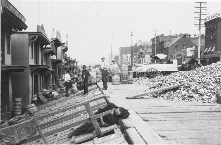 Workers stand with baskets for unloading oysters, West St. looking north from Charles St., Greenwich Village, c. 1890 Source: Getty Images