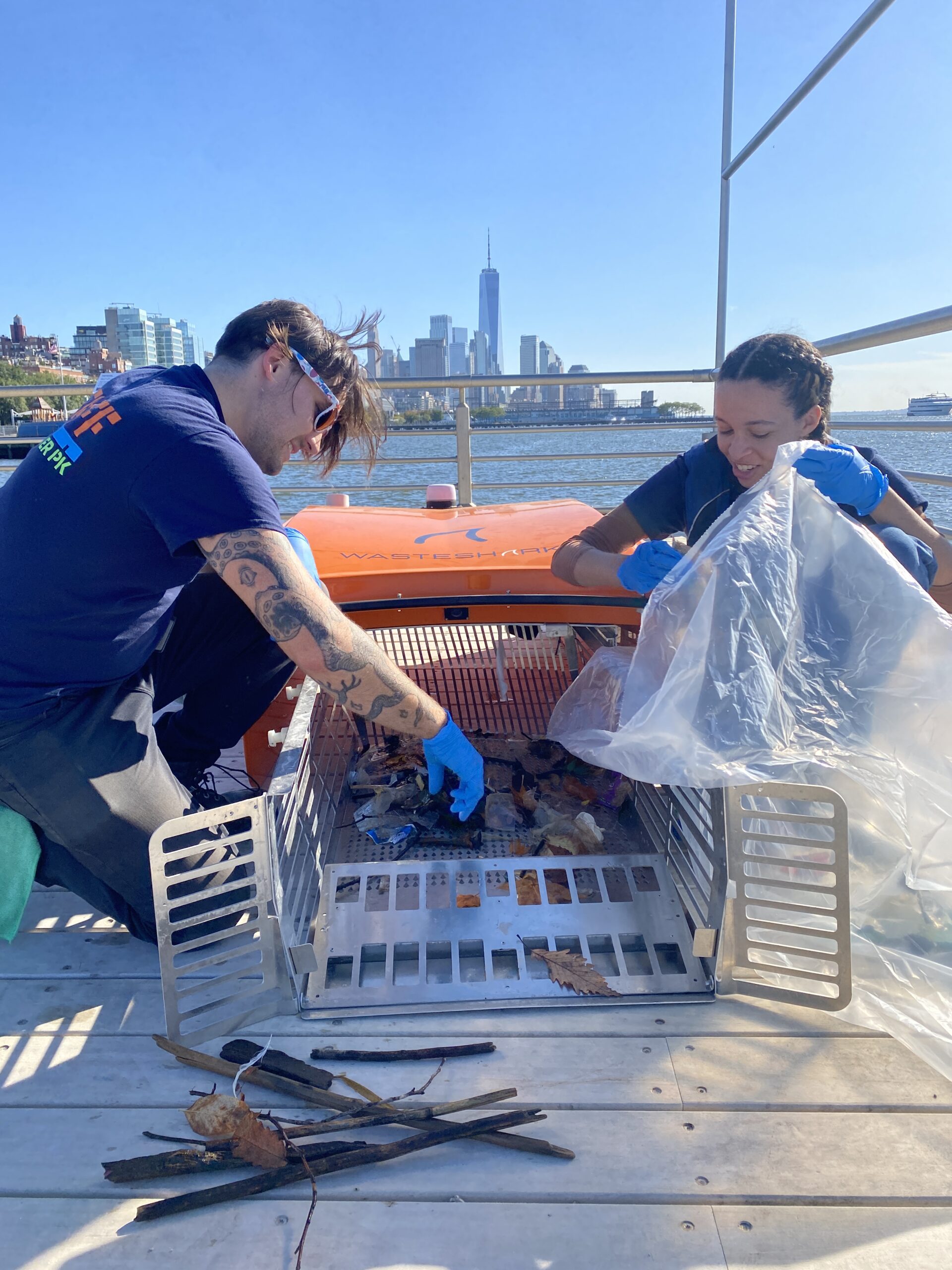 Two HRPK River Project workers collecting debris from a WasteShark