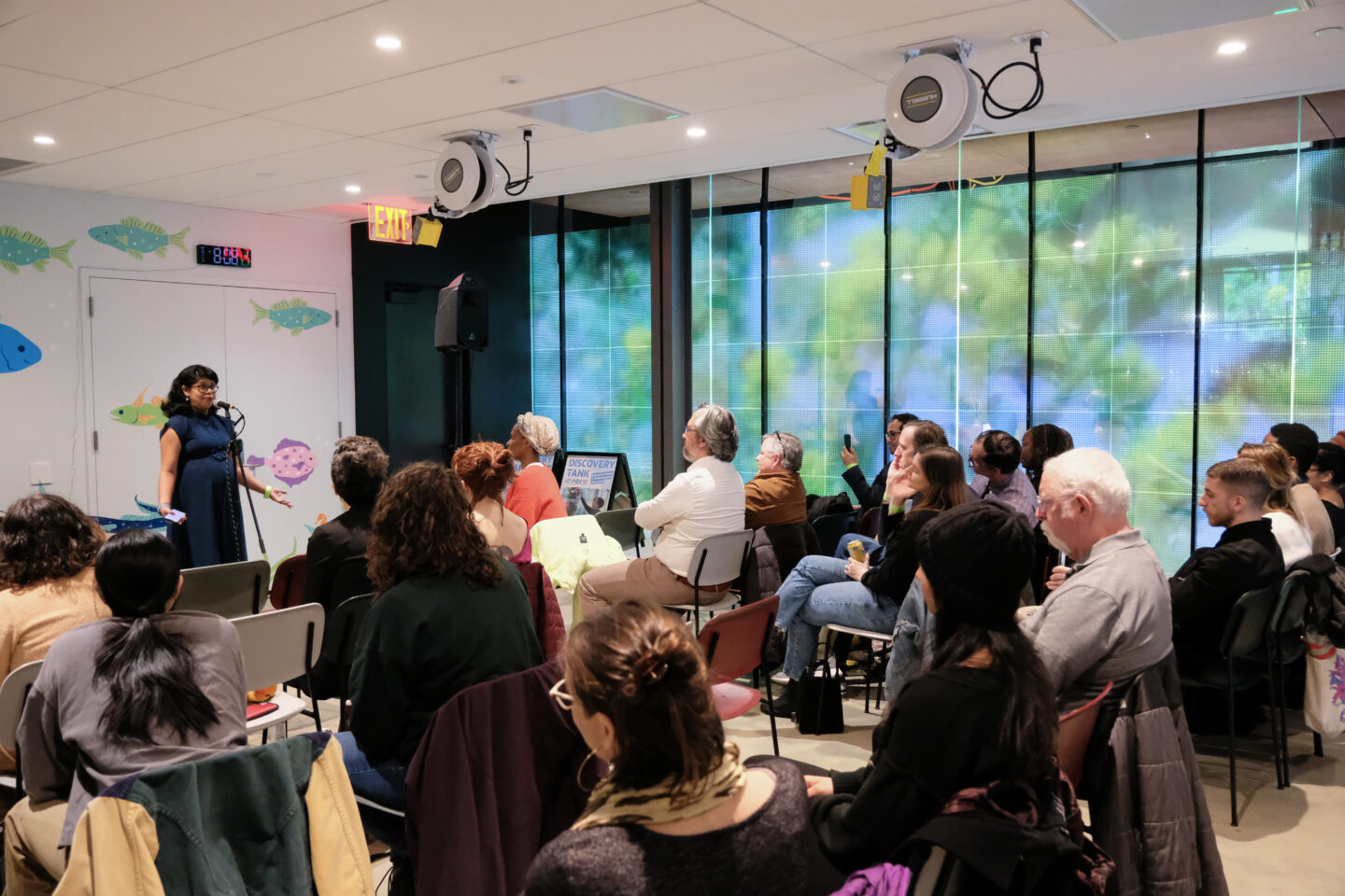 A speaker in front of an audience at a Discovery Tank event