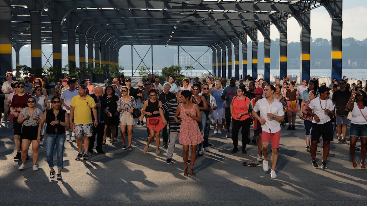 Talia Castro-Pozo leads a group in a dance lesson during a Sunset Salsa class on Pier 76