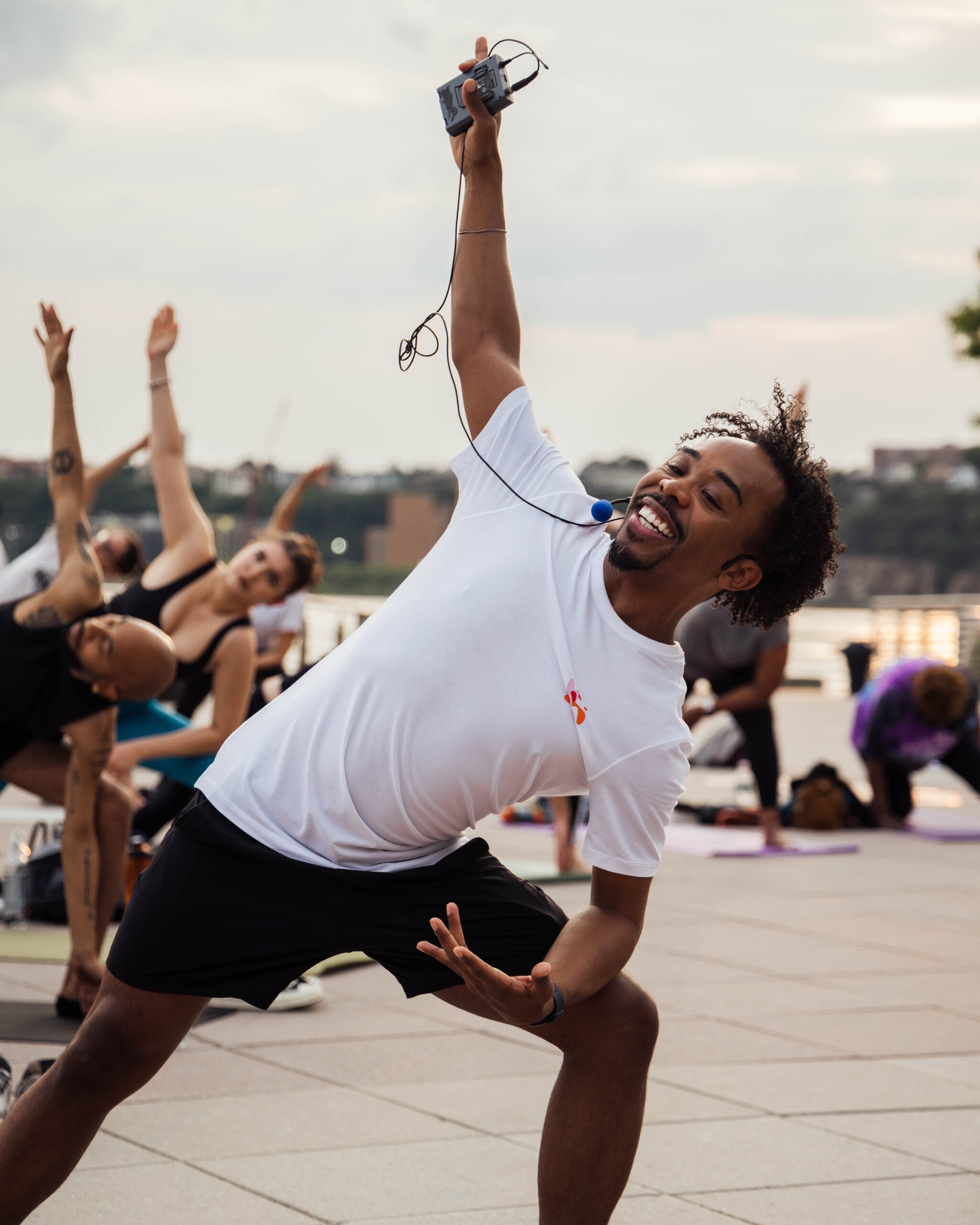 A Healthy on the Hudson fitness class instructor leads a group in a stretch