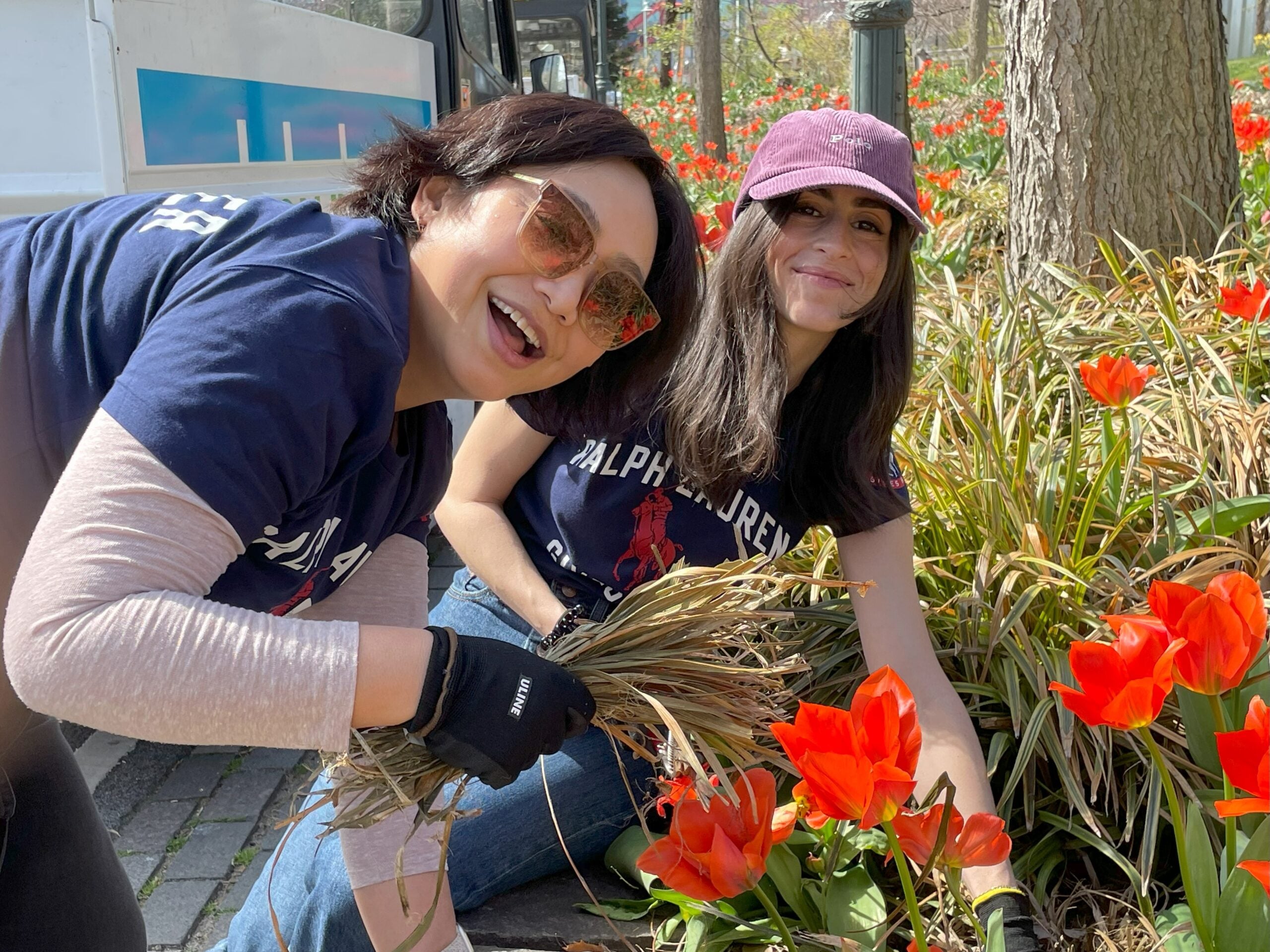 Two volunteers from Ralph Lauren helping with planting in a Park garden bed