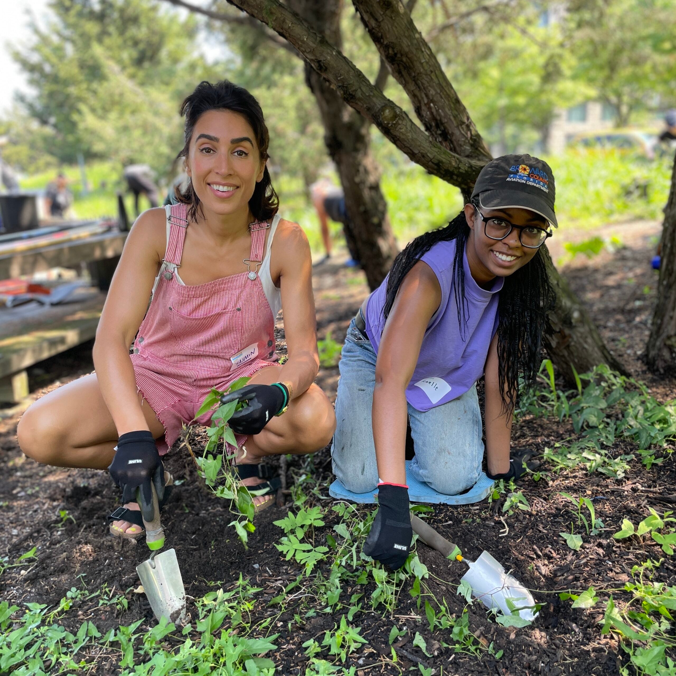 Two volunteers planting and weeding in a Park garden