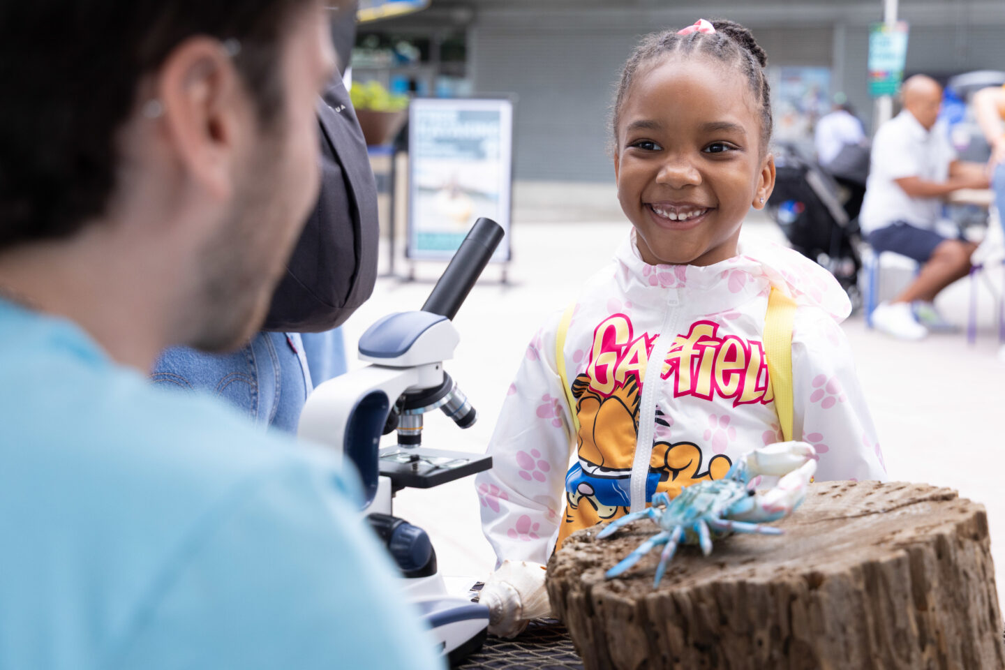 A student smiles while speaking with an HRPK River Project staffer at a SUBMERGE Marine Science Festival tent