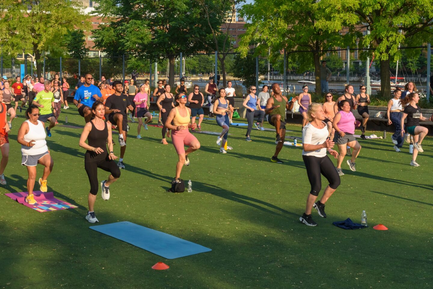 Participants in a Healthy on the Hudson class run in place on the Pier 25 turf field