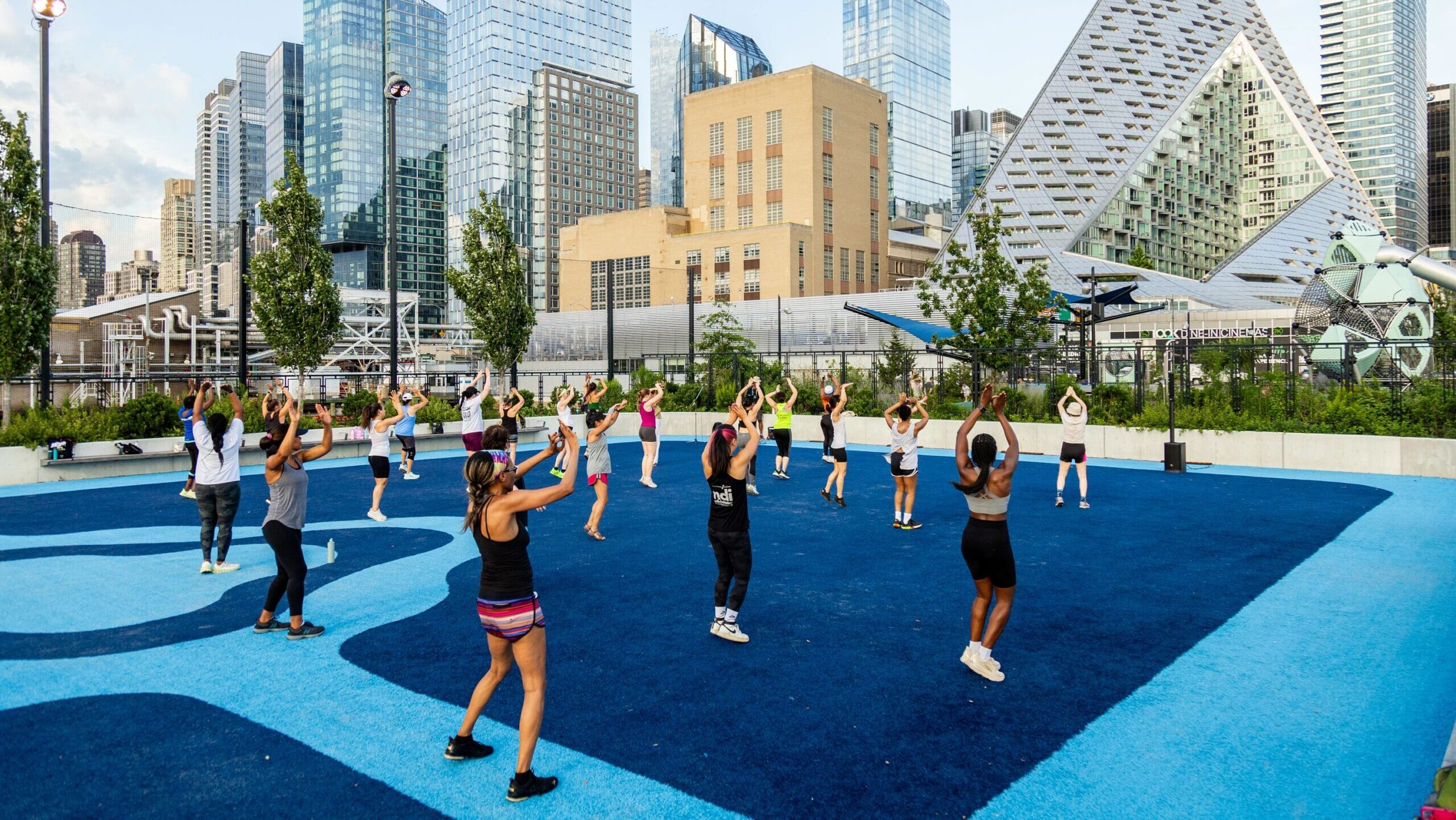 Healthy on the Hudson class participants exercise in unison on the Pier 97 Athletic Field