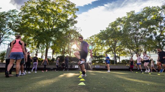 Healthy on the Hudson class participants do step drills in between cones on the Pier 25 Turf Field