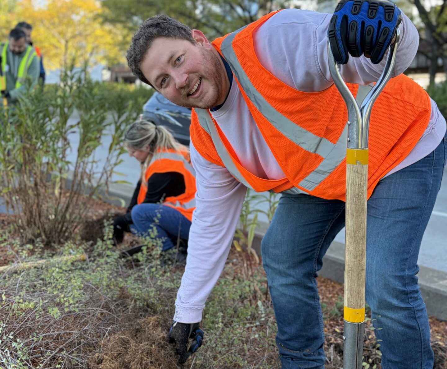 A volunteer in safety jacket smiling at camera