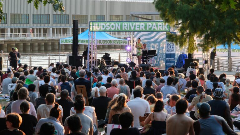 Jasmine Amy Rogers performing in front of a large audience during a Broadway by the Boardwalk performance at Clinton Cove