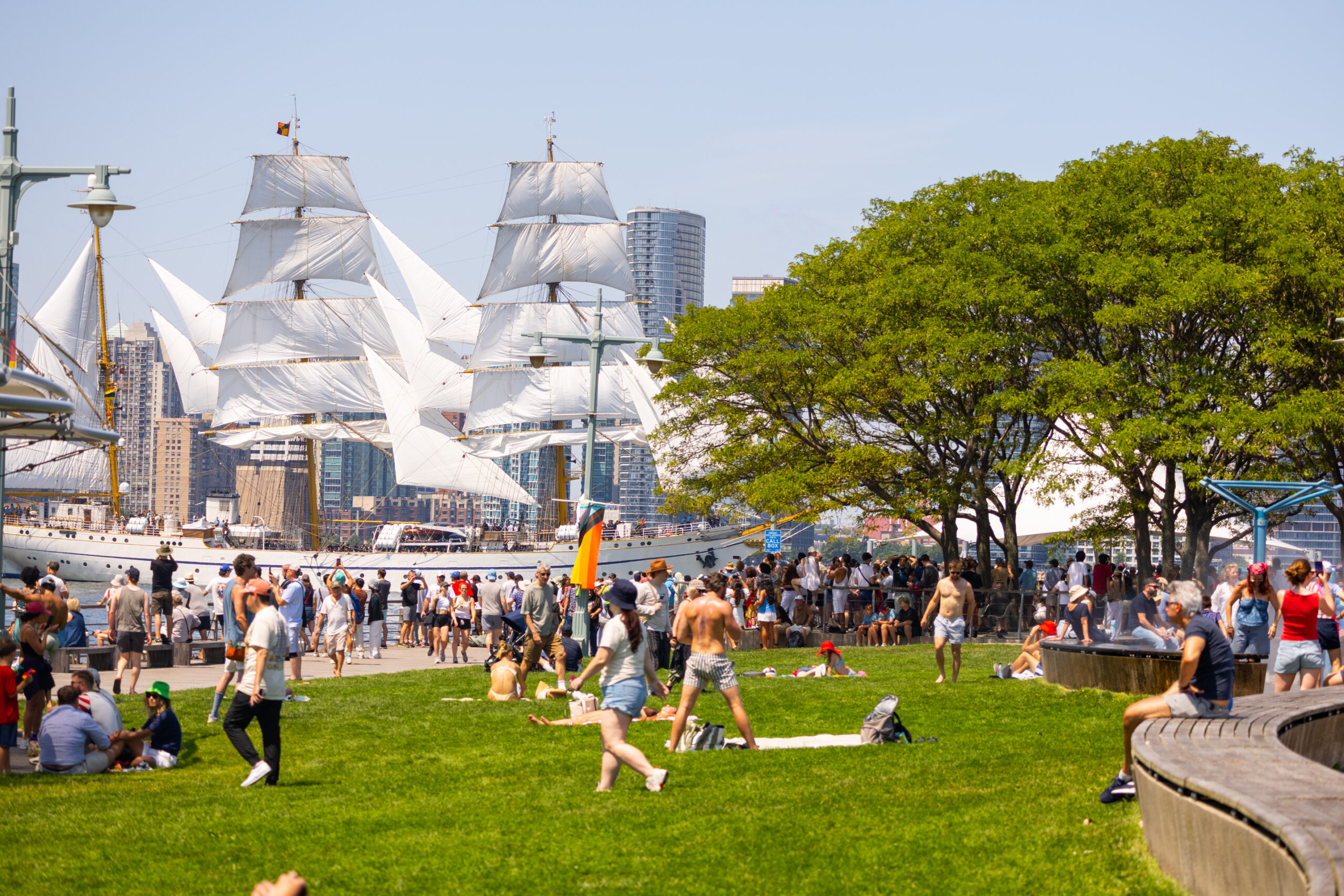 Crowds on lawn at Pier 45 as tall ship sails by